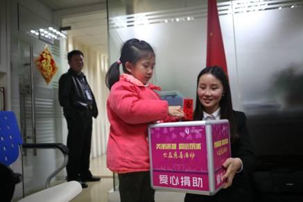 一名5歲的女童將剛拿到的壓歲錢放入捐款箱中
